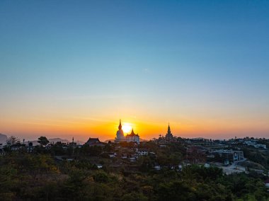 Aerial view beautiful sunrise above Big White Five buddha Statues in Wat Phra That Pha Son Kaew temple at Phetchabun Thailand clipart