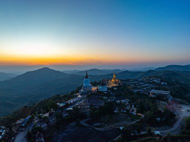 Aerial view beautiful sunrise above Big White Five buddha Statues in Wat Phra That Pha Son Kaew temple at Phetchabun Thailand clipart