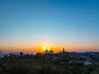 Aerial view beautiful sunrise above Big White Five buddha Statues in Wat Phra That Pha Son Kaew temple at Phetchabun Thailand clipart