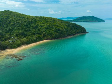 Sarmal yolları, kristal berraklığında turkuaz suları ve parçalı bulutlu bir gökyüzünün altındaki uzak adaları olan yemyeşil bir kıyı şeridinin nefes kesici hava manzarası. Lam Nga Silay Adası 'nda, Phuket. yeşil deniz