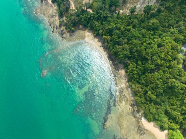 Sarmal yolları, kristal berraklığında turkuaz suları ve parçalı bulutlu bir gökyüzünün altındaki uzak adaları olan yemyeşil bir kıyı şeridinin nefes kesici hava manzarası. Lam Nga Silay Adası 'nda, Phuket. yeşil deniz