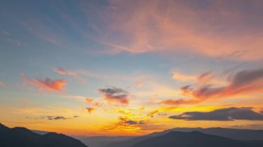 Dağların tepesinde güneşin doğuşuyla tatlı gökyüzünün havadan hiperaktif görüntüsü