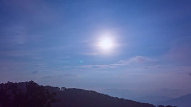 Dağların üzerinde beyaz bulutlar olan mavi gökyüzünün zaman atlaması