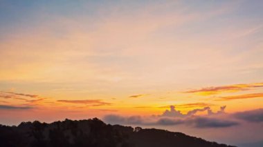 Zaman akıp gidiyor dağların üzerinde gün doğumunda güzel sarı gökyüzü