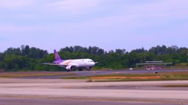 Phuket, Tayland - 11 Aralık 2024: Bangkok Hava Jeti iniş pistine iniyor, iniş takımları temas kuruyor ve bir duman bulutu yaratıyor.