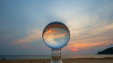 Günbatımında parlak bir gökyüzünün altında çamurlu bir sahilde karaya oturmuş gemi enkazının büyüleyici görüntüsü. Sıcak turuncu ve mor renkler suyun durgunluğuyla tezat oluşturuyor. çarpıcı gökyüzü