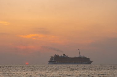 Lüks bir yolcu gemisinde gün batımı gökyüzünü turuncu ve pembeye çevirir ve çarpıcı bir manzara yaratır. Günün Patong 'da güzel bir geceye dönüşmesi gibi ufkun dingin güzelliğini tecrübe edin. 