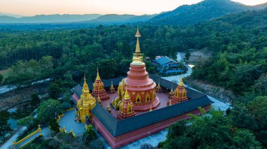 Doi Phra Chan (Daibutsu) perspektifinden yapılan Phra Yai Wat Phra karmaşık altın kuleleri ile büyüleyici bir Tayland tapınağı sergilenmektedir. Gün batımında çekilen karmaşık altın mimari ile..