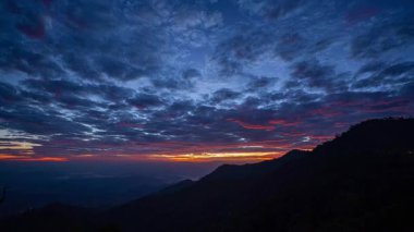 Zaman, alacakaranlıkta dağların tepesindeki gökyüzünü hızlandırıyor..