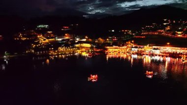 Geceleri göl kenarında parıldayan ışıklarla Çin köyü.