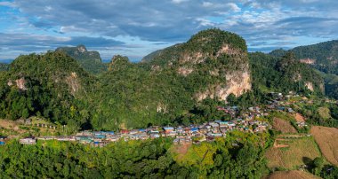 Güneşin erken saatlerinde sisli vadileri ve arkada dramatik zirveleri olan bir dağ köyünün nefes kesici hava manzarası.. 