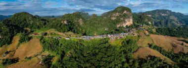 Güneşin erken saatlerinde sisli vadileri ve arkada dramatik zirveleri olan bir dağ köyünün nefes kesici hava manzarası.. 