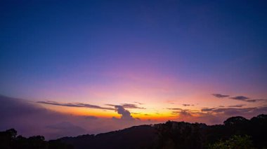 Alacakaranlıkta, gün batımı gökyüzü ile zaman akıp gidiyor.