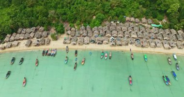 Phang Nga. Sahil boyundaki küçük kulübeler, yemyeşil ormanlarla çevrili. Balıkçı tekneleri Turkuaz Suları 'nda demirlidir..