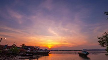 Günbatımında terk edilmiş teknelerin üzerinde çarpıcı bir zaman kaybı.