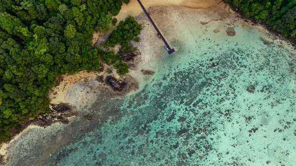Surin Adaları 'ndaki Ao Mai Ngam' ın muhteşem kuş bakışı görüntüsü. Sahilin karşısında konaklamanın olduğu bir iskele var. Mercan resifleri ve balık sürüleri var. Dalgıçlar için bir varış noktasıdır..