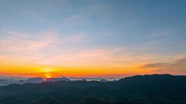 Dağ sırasının üzerinde çarpıcı güneşin yükselişinin havadaki hiper yanılma görüntüsü