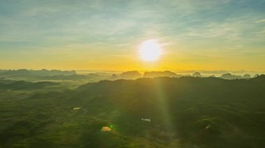 Dağ vadisinde yükselen altın gündoğumunun havadan hiperaktif görüntüsü