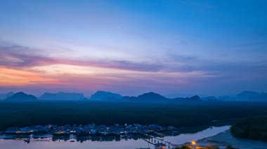 Alacakaranlıktaki Bang Phat balıkçı köyündeki gökyüzü manzarası. Mangrov ormanlarıyla çevrili küçük, ıssız bir adada yaşayan bir balıkçı köyündeki alacakaranlık gökyüzünün yansıması..