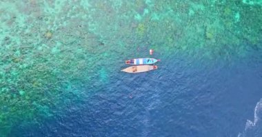 Mavi denizde şnorkelle yüzen turistlerin hava manzarası 