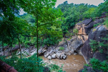 Nehir vadisinin güzel manzarası, kayalıkları öpmek ve uçurumları birbirine bağlayan dar köprüler gibi yüksek kaya oluşumlarıyla dolu yemyeşil ormanlarla çevrilidir. Rive 'de muhteşem bir öpüşme.
