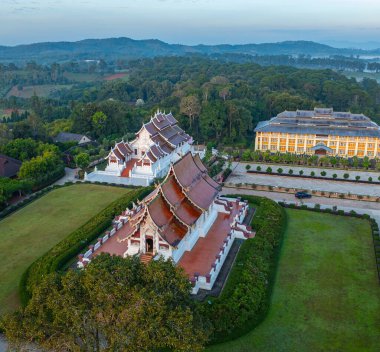 Sis arka planında Baan Khan Tapınağı 'nın havadan görünüşü. Perspektif, güzel bir gökyüzü altında sis ve kırsal alanlarla çevrili karmaşık altın kuleleriyle çarpıcı bir Tayland tapınağını gözler önüne seriyor..
