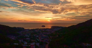 Sahil kasabasının yukarısında günbatımında sarı bulutlu hava manzarası