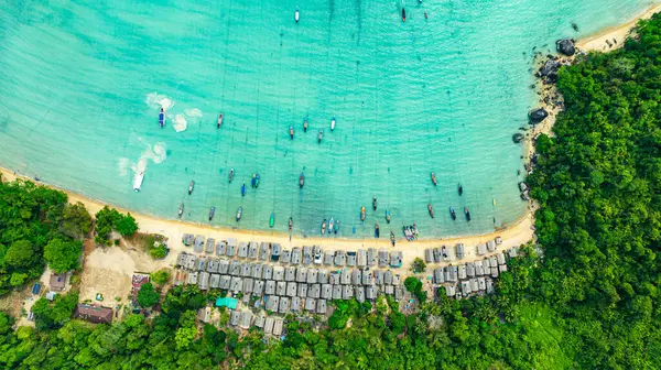 Morgan Köyü 'nün Surin Adası' ndaki doğal güzelliklere gizlenmiş havadan görüntüsü. Kıyı şeridi boyunca yemyeşil ormanlarla çevrili küçük kulübeler. Balıkçı tekneleri turkuaz sularda demirli..    