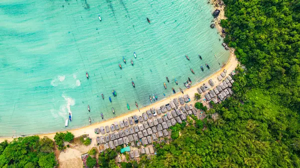 Morgan Köyü 'nün Surin Adası' ndaki doğal güzelliklere gizlenmiş havadan görüntüsü. Kıyı şeridi boyunca yemyeşil ormanlarla çevrili küçük kulübeler. Balıkçı tekneleri turkuaz sularda demirli..    