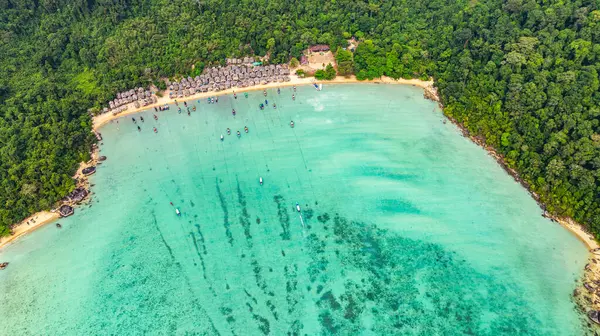 Morgan Köyü 'nün Surin Adası' ndaki doğal güzelliklere gizlenmiş havadan görüntüsü. Kıyı şeridi boyunca yemyeşil ormanlarla çevrili küçük kulübeler. Balıkçı tekneleri turkuaz sularda demirli..    