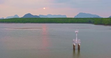 Deniz fenerinin üstündeki gün batımının havadan görünüşü
