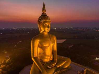 Muang Ang Tayland 'da, Tayland' ın büyük altın Buda simgesinin arkasında gün batımı..