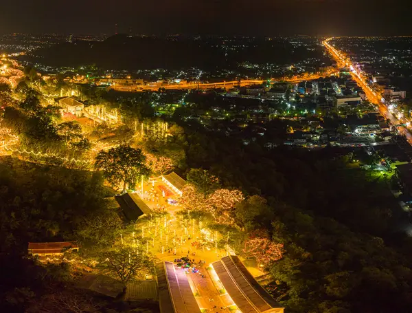 Havai fişeklerin göz kamaştırıcı gösterisi aydınlatılmış tepe sarayının üzerinde gece gökyüzünü aydınlatıyor. Bu coşkulu kutlama, karanlık gökyüzü ve Phetchaburi festivali havai fişekleriyle güzel bir tezat oluşturuyor..