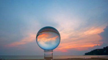 Camdan bir küre içindeki renkli akşam bulutlarının zaman aşımı