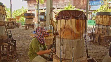 Tad davulunu yapan erkek ve kadın, ortasında delik olan büyük bir ahşap parçasından yapılmış çift taraflı bir davuldur..