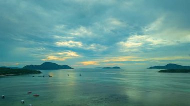 Dalgalar çekildiğinde teknelerle sakin denizde gündoğumunun hava hiper yanılma görüntüsü