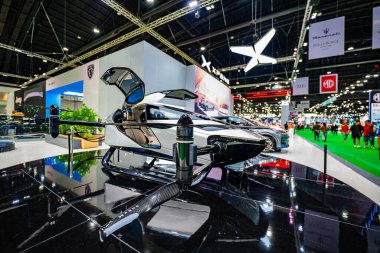 Bangkok, Tayland - 04 Nisan 2024: Bir otomotiv ve teknoloji sergisinde sergilenen son teknoloji ürünü bir taksinin düşük açılı görüntüsü. Pervaneli ve aerodinamik tasarımı olan parlak bir uçak.