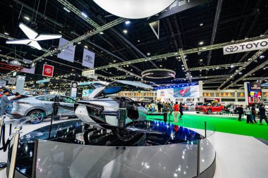 Bangkok, Tayland - 04 Nisan 2024: Bir otomotiv ve teknoloji sergisinde sergilenen son teknoloji ürünü bir taksinin düşük açılı görüntüsü. Pervaneli ve aerodinamik tasarımı olan parlak bir uçak..