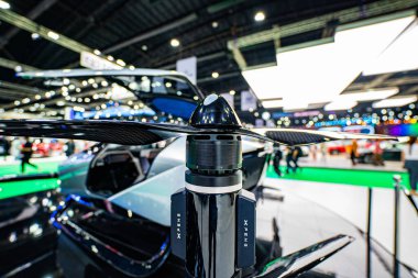 Bangkok, Tayland-Nisan 04-2024: Bir otomotiv ve teknoloji sergisinde sergilenen son teknoloji ürünü elektrikli hava taksisinin alçak açılı görüntüsü. Pervaneli ve aerodinamik tasarımı olan parlak bir uçak.
