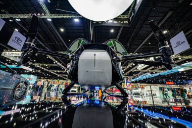 Bangkok, Tayland, Nisan 04 - Nisan 2024: Bir otomotiv ve teknoloji sergisinde sergilenen son teknoloji ürünü elektrikli hava taksisinin alçak açılı görüntüsü. Pervaneli ve aerodinamik tasarımı olan parlak bir uçak..