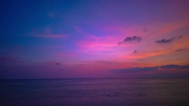 Okyanusun üzerindeki alacakaranlıkta renkli gökyüzünün zaman kayması