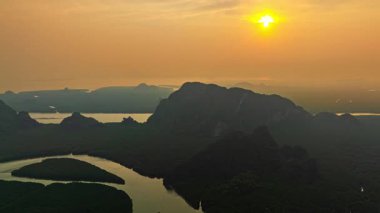 Güneşin doğuşunda mangrov kanalında süzülen hava hiper yanılma görüntüsü
