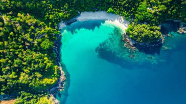 Orman gölgeleri sabahları sahili kaplıyor. Ormanda saklı küçük beyaz bir sahil ve yeşil deniz. Ziyaret etmek zor. Özgürlük Kumsalı ünlü turistik merkezin yakınında Patong..