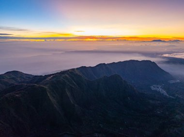 Penanjakan Peak Bromo 'da, güneşin doğuşunu izleyen en yüksek bakış açısı. İnanılmaz volkan kraterinden sürekli beyaz duman püskürtür. Güneş doğarken şaşırtıcı Bromo volkanları.