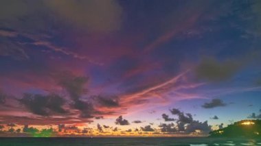 Çarpıcı günbatımında denizin üzerinde renkli bulutların zaman akışı 