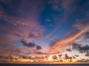 Pembe ve turuncu renkli canlı bir günbatımının çarpıcı bir sahnesi Karon plajı Phuket 'in üzerinde gökyüzünü aydınlatıyor. Doğanın inanılmaz ışığı bulutlu gökyüzü, harika gün batımı