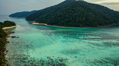 Berrak turkuaz sularla çevrili yemyeşil tropikal adaların çarpıcı hava manzarası. Mercan resifleri ve kumlu kıyılar derin mavi okyanusa karşı çok güzel tezat oluşturuyor. Surin Adaları