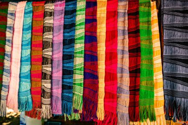 Karmaşık desenlere sahip kalın ve zengin renklerden oluşan geleneksel el dokuması kumaşların canlı bir gösterisi. Kuzeydeki dokuma geleneklerinin zanaatkarlığı ve kültürel mirası