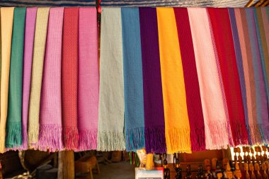 Karmaşık desenlere sahip kalın ve zengin renklerden oluşan geleneksel el dokuması kumaşların canlı bir gösterisi. Kuzeydeki dokuma geleneklerinin zanaatkarlığı ve kültürel mirası