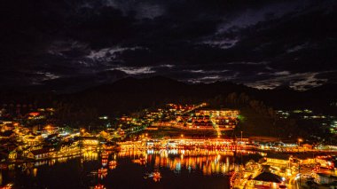 Alacakaranlıkta, köyden gelen ışıkların yansımaları Çin tarzı renkli ışıklı yapılar halinde göl kıyılarını kaplıyordu. Ban Rak Thai, Mae Hong Son 'da popüler bir turistik merkezdir.